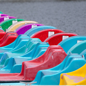 a row of colorful paddle boats docked a row of colorful paddle boats docked.