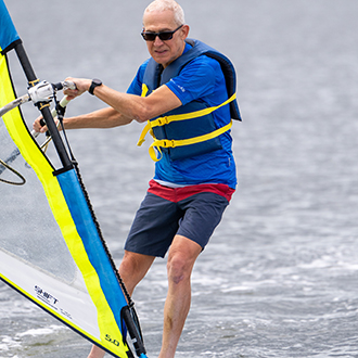 An older man windsurfing. An older man windsurfing.