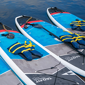 stand up paddle boards ready to be launched Three standup paddle boards lined up ready to be launched.