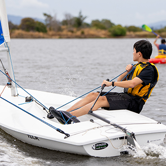 A boy doing performance sailing at shoreline lake A boy doing performance sailing at shoreline lake