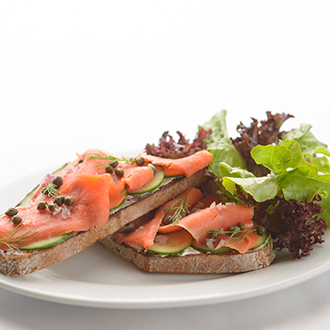 Two slices of bread topped with salmon and capers. Two slices of bread topped with salmon and capers.